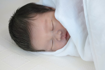 Closeup a baby sleeping comfortably on the bed