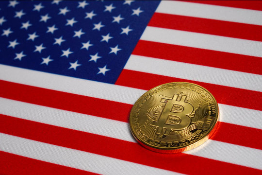 Golden Bitcoin on the flag of USA. Close-up, copy space