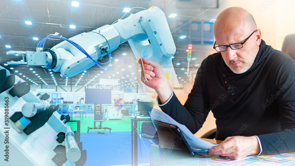 Poster an engineer in a black sweater next to the robot. study of technical documentation. setting up an in