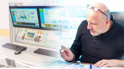 Engineer at his Desk on the background of the control panel. Dispatcher at an industrial enterprise. Control over the work of the automated Assembly line. Modern production.