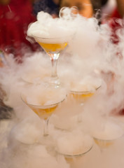 Champagne slide. Champagne glasses pyramid or fountain and dry ice steam