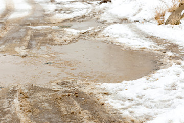 Snow puddle, with traces of car wheels