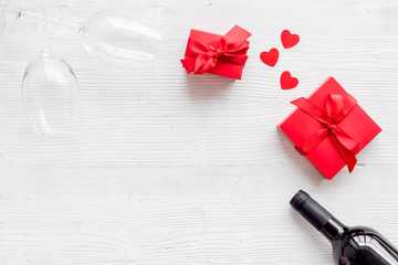 Valentines Day concept with wine, glasses, red present box on white background top-down copy space