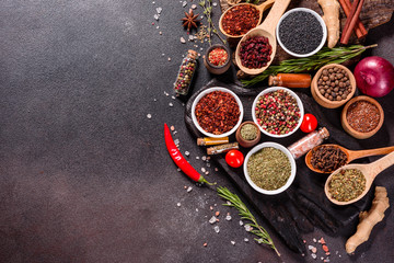 Spices and herbs over black stone background. Top view with free space for menu or recipes