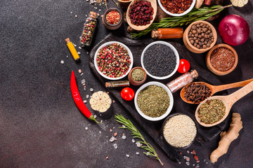 Spices and herbs over black stone background. Top view with free space for menu or recipes