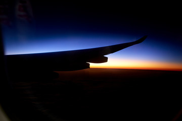 Naklejka na ściany i meble Wing of an aeroplane with sunset