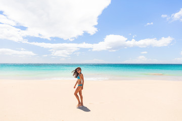 Fototapeta na wymiar Beach vacation paradise Hawaii tourist woman walking on white sand wide perfect beach summer holiday in the Caribbean.