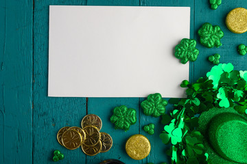Flat lay, St. Patrick's Day, white card for congratulation. March 17, on a green background with...