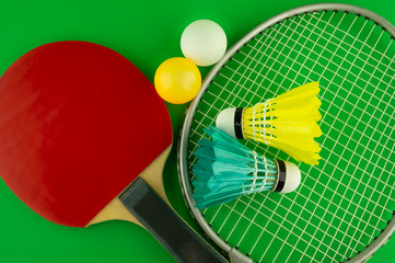 Ping pong and badminton rackets on green