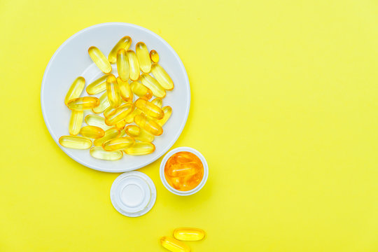  Fish oil supplement, medical and health concept, top view of Soft gel gapsules on yellow background