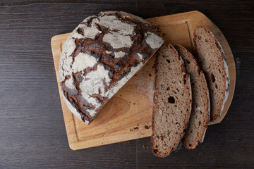 Fresh bread on the table close-up in flour placer. Fresh bread on the kitchen table. Healthy eating and the traditional concept of the bakery. Rustic style