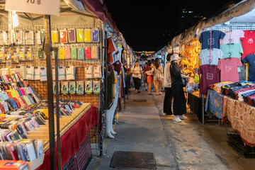 Fototapeta na wymiar Tourist and locals walking and shopping at Rachada Night train market (Talad Rot Fai). market with plenty of shops with colorful canvas roofs at night in Bangkok, Thailand