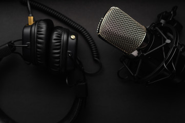 Podcasts and Stream. Flat lay. Studio condenser microphone black with professional headphones