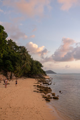 Beautiful sunset at the sea in Thailand on the island of Koh Samui. Sun, sea, beach, palm trees and waves. Spiritual pastime in the open air