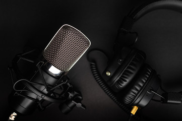 Podcasts and Stream. Flat lay. Studio condenser microphone black with professional headphones