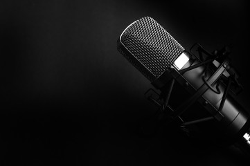 Condenser black studio microphone on a black background. Streamer, podcasts, music background
