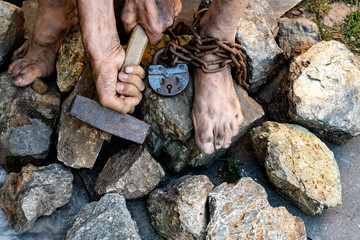 Hard work. Hands holding a hammer. The desire to free oneself.