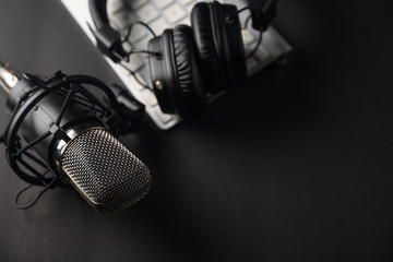 Flat lay, Studio microphone with professional headphones on a PC keyboard. Black on a black...