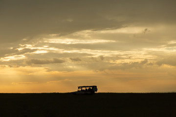 silhouette of a jeep on the savannah at sunrise