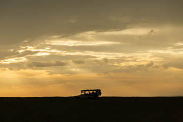 Fototapeta premium silhouette of a jeep on the savannah at sunrise