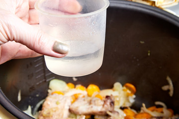 Cooking. Roasting pieces of meat with carrots or onions in a multicooker bowl