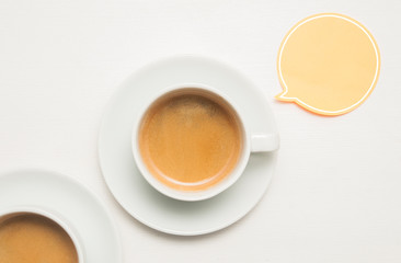 Cup of coffee on a white wooden table with orange and blue balloons with copy space