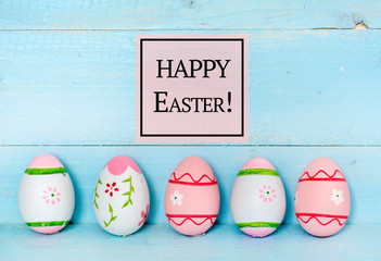 Easter Greeting Card with Colorful Easter Eggs and Happy Easter Text on a Blue Wooden Background 