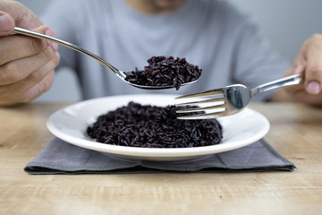 Asian man hand eating healthy rice berry.