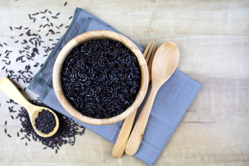 Riceberry cooked in a wooden cup Wooden spoons and wooden forks placed on fabric.
