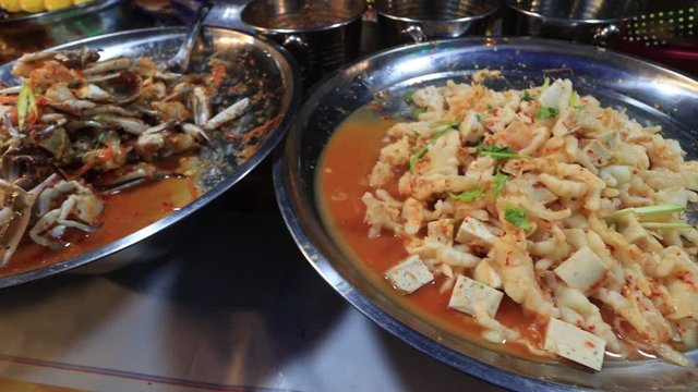 Asian street food at night market. Seafood curry with crabs, calamari and prawns 