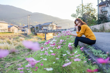 Young woman in poppy field of flowers in Yufuin Town, Oita, Japan