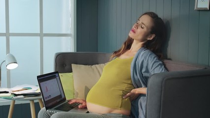 Closeup pregnant businesswoman having back pain. Pregnant woman working laptop. - Powered by Adobe
