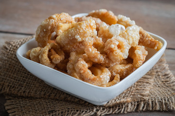 Pork rind, pork crackling in white bowl.