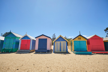 Fototapeta na wymiar Brighton Beach huts/boxes on a blue sky sunny day with bright colours and textures