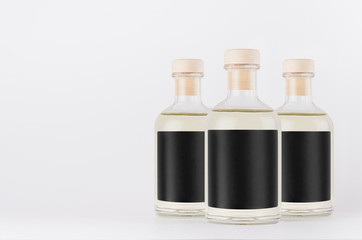 Group glass bottles for cosmetic, perfume, alcohol drink with black label, cork, yellow liquid on white background, mock up for  design.