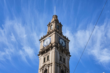 Historic Victorian style clock tower in Melbourne CBD with blue sky and white clouds © Orion Media Group