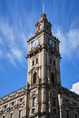 Fototapeta na wymiar Historic Victorian style clock tower in Melbourne CBD with blue sky and white clouds