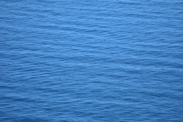 Blue water surface pattern with cross waves similar to woven fabric.