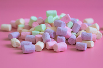 Obraz na płótnie Canvas Colorful marshmallows on pink background, macro. Fluffy marshmallows texture close up in pastel colors