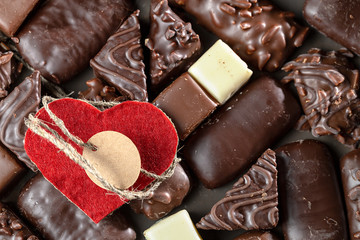 Appetizing food background. Assortment of chocolate handmade candy and red heart card for valentines day. Chocolate background. 