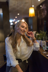 Blondine am Tresen in einem Hotelfoyer