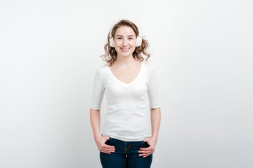 Smiling girl posing in headphones. Isolated on a white backgroun