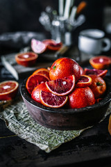 Red oranges with slices on a vintage old wooden boards