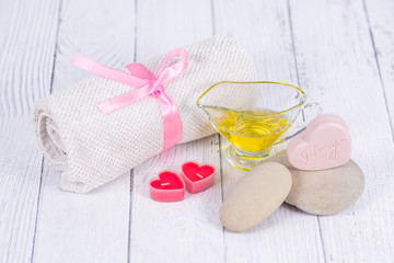 The concept of a Spa on Valentine's Day. Candles, soap in the form of a heart with text I love you, stones, massage oil and a towel on a wooden background. Relaxation and wellness care. Bath procedure