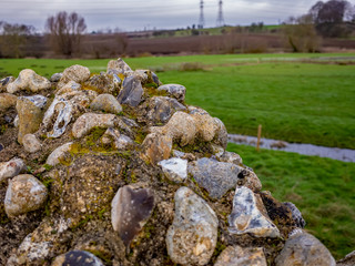 Selective focus on ancient stone Roman wall at the ancient Roman camp in Caistor St Edmond in the county of Norfolk