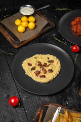 Appetizers from grilled vegetables, potatoes, crushed beans or hummus, stewed cabbage. Octoberfest party dinner. Festive table with delicious food on black boards.