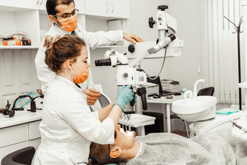 Two dentists treat a patient. Professional uniform and equipment of a dentist. Healthcare Equipping a doctor’s workplace. Dentistry