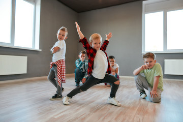 Hip hop style. Group of cute little boys in fashionable clothes dancing and posing in the studio. Choreography class. Kids and sport. Full length