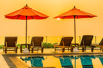 Beautiful sunrise around with umbrella and chair outdoor swimming pool