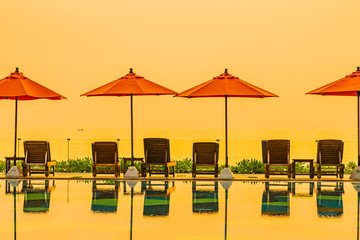 Beautiful sunrise around with umbrella and chair outdoor swimming pool